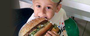 Un pequeño se deleita comiendo una hamburguesa Big Mac.